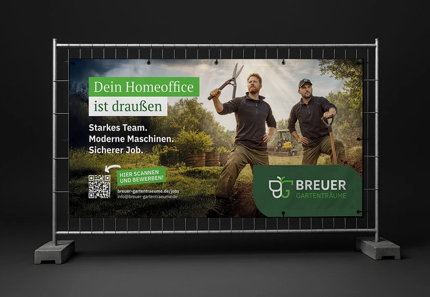Bauzaunbanner Breuer Gartenträume — Recruiting-Motiv mit Headline "Dein Homeoffice ist draußen"